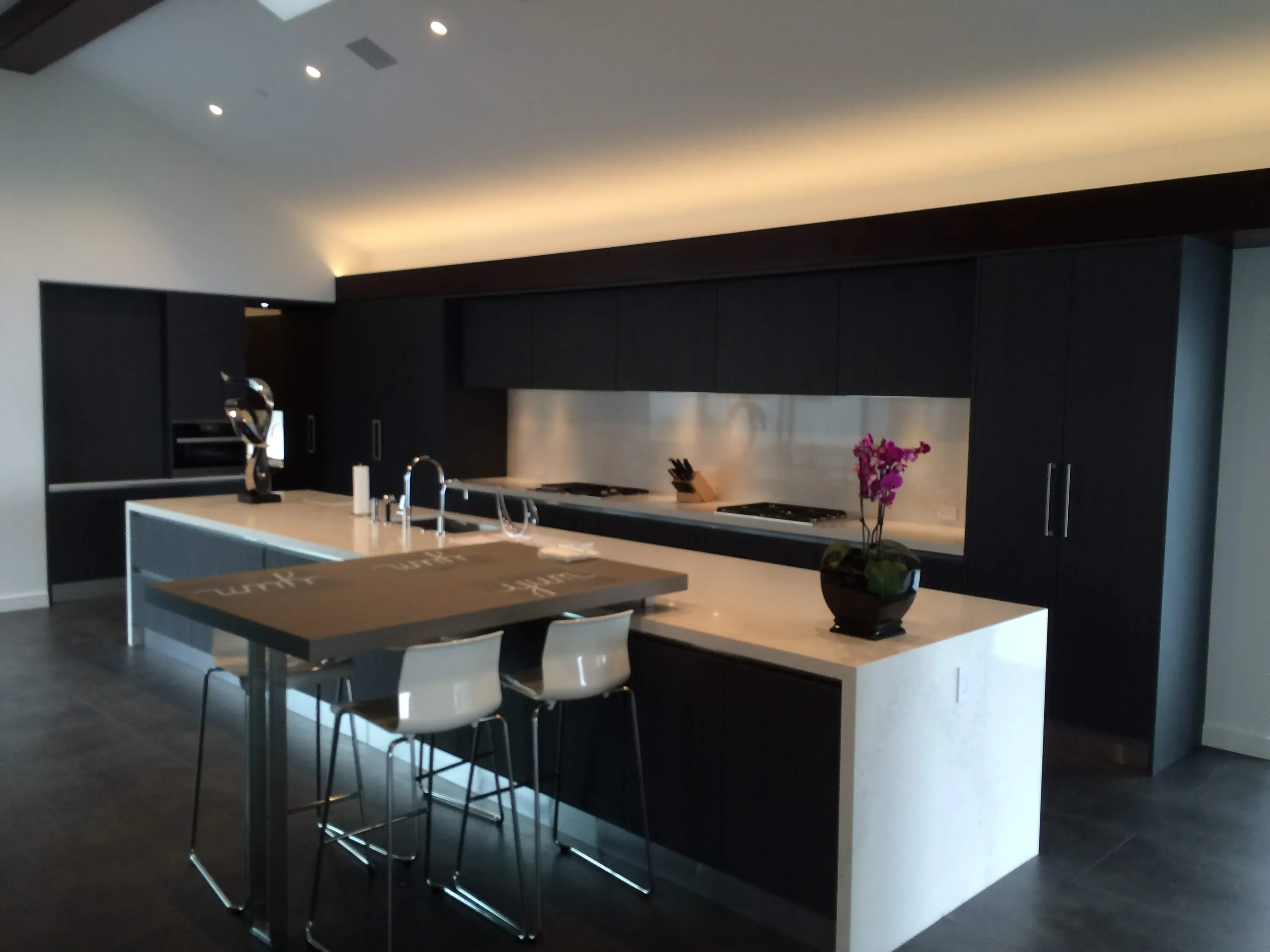 Dark kitchen with lit island and bar