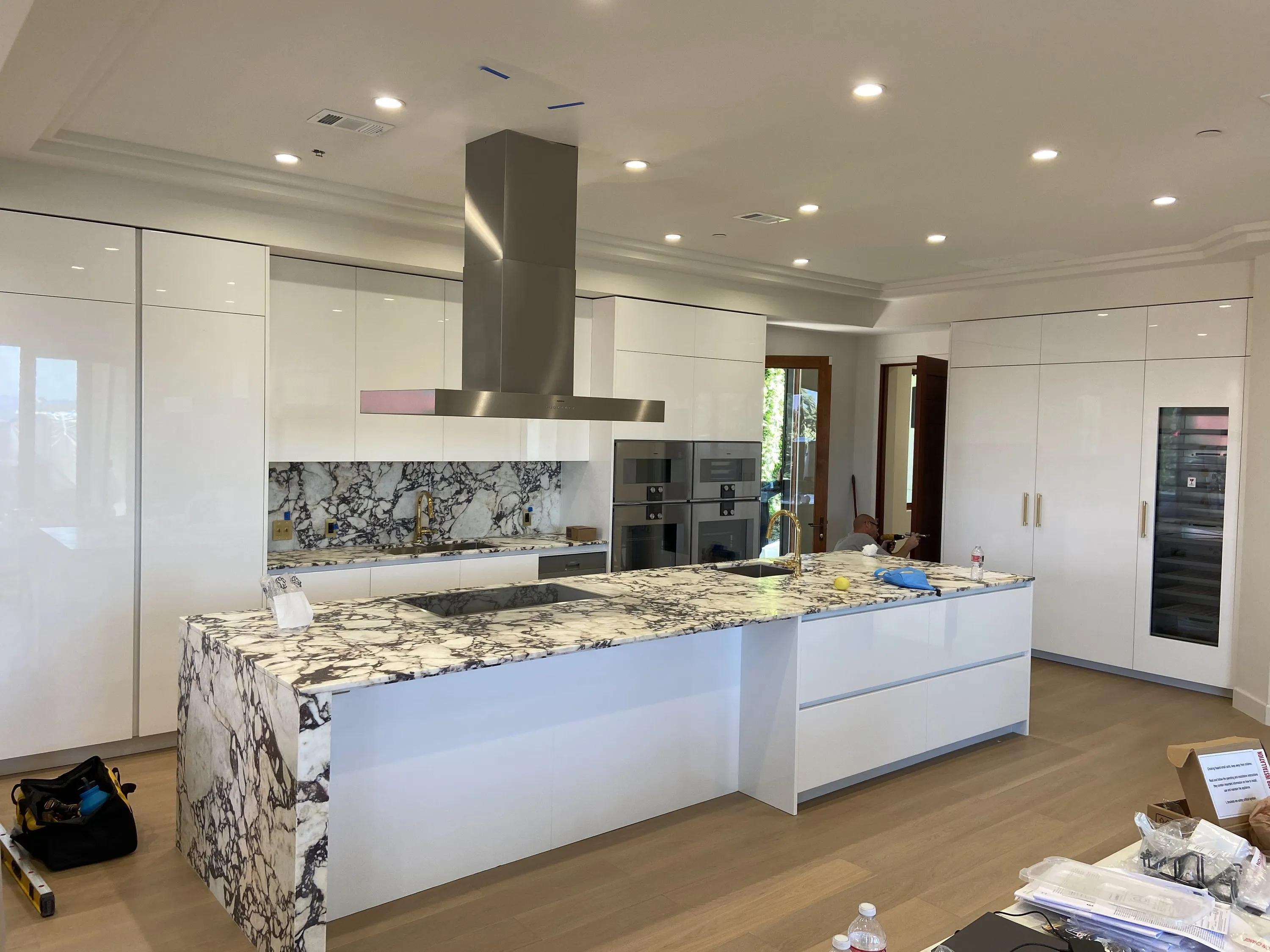 Gloss white kitchen, stone waterfall island