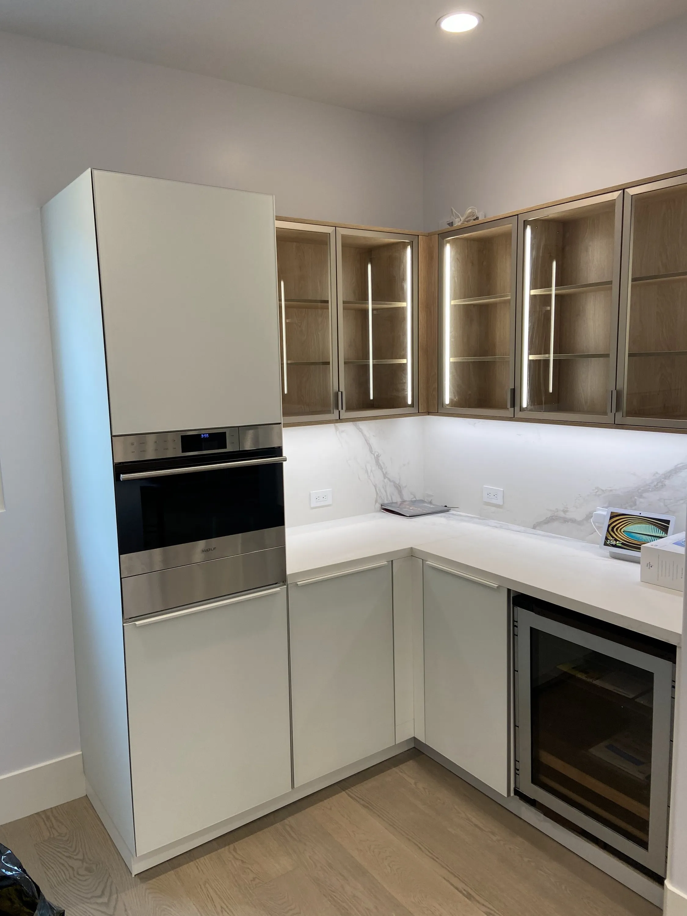 Corner cabinetry with glass-front uppers and wine fridge