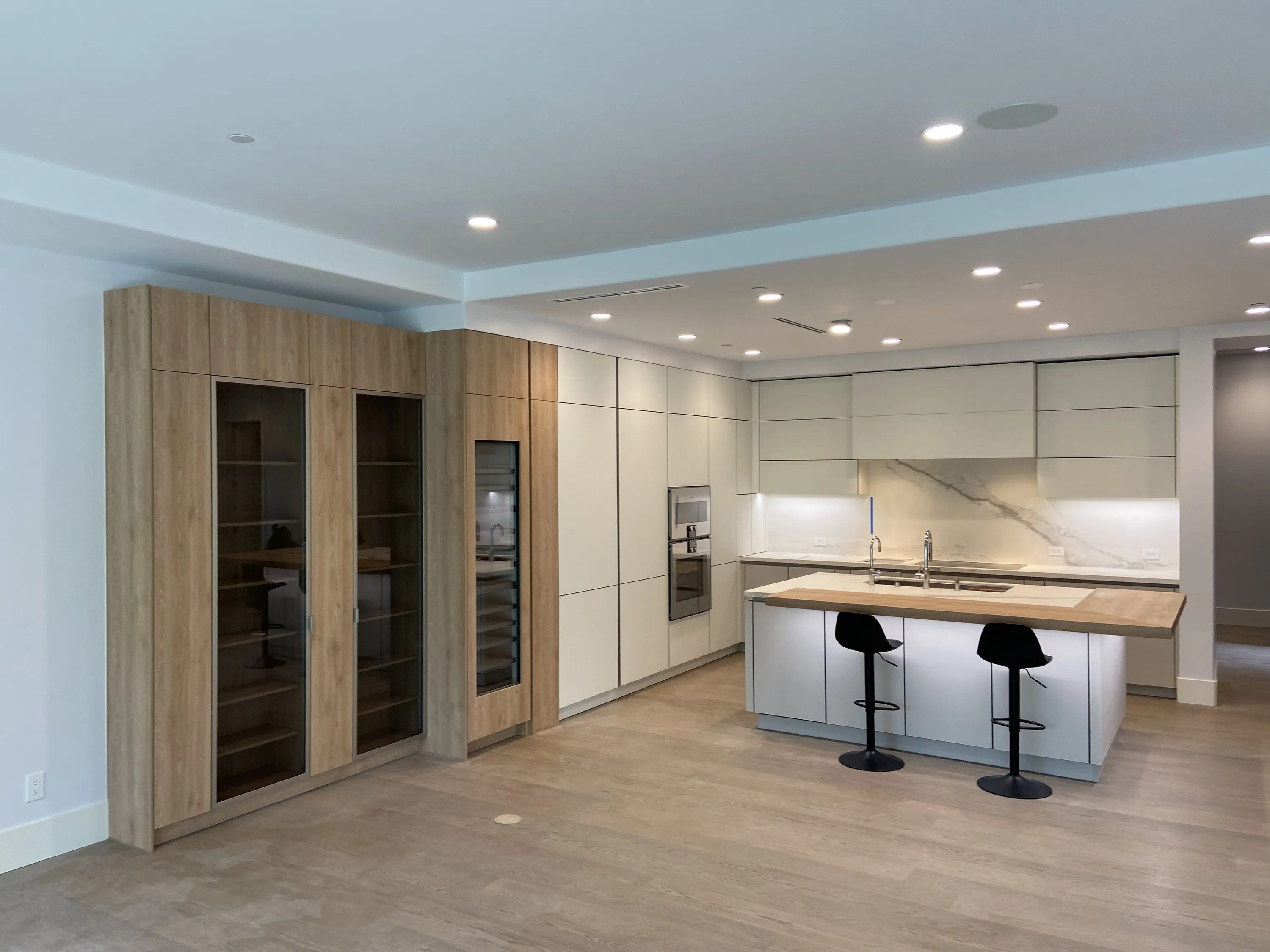 Kitchen by Nestor: light cabinetry with oak wine cabinets